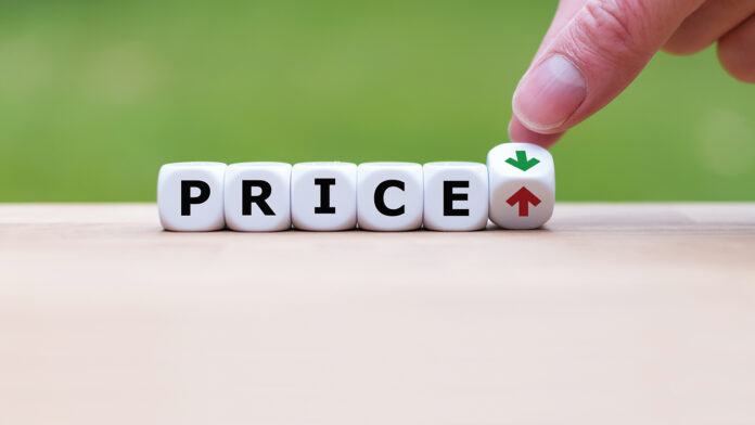 Hand is turning a dice and changes the direction of an arrow symbolizing that the price is going down (or vice versa)