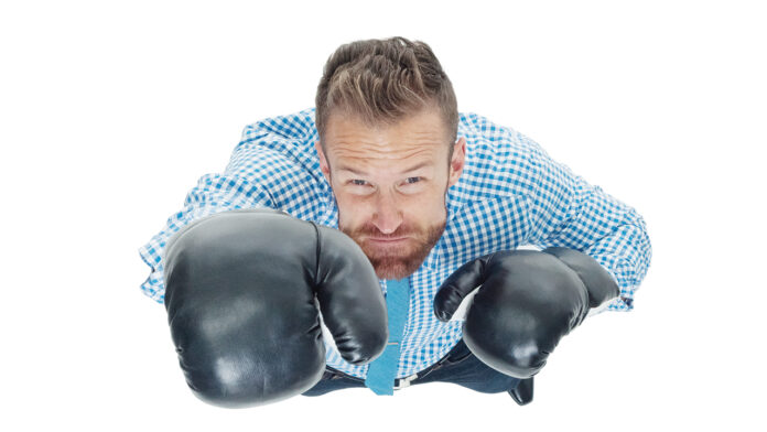 One man only / full length / directly above view / looking up of 30-39 years old adult handsome people caucasian young men / male businessman / business person standing in front of white background and boxing who is punching / fighting / sport Battling a big competitor