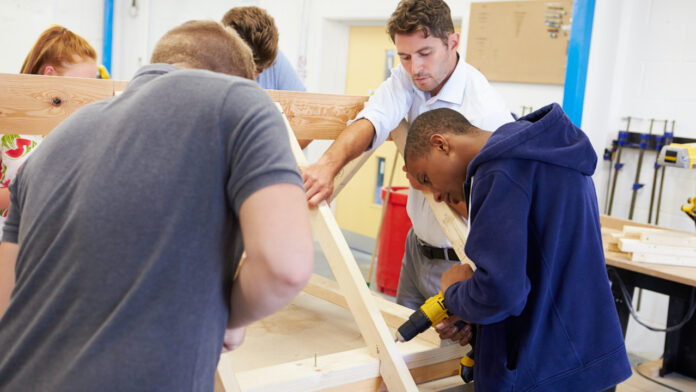 Teacher Helping College Students Studying Carpentry skilled labor trades construction training
